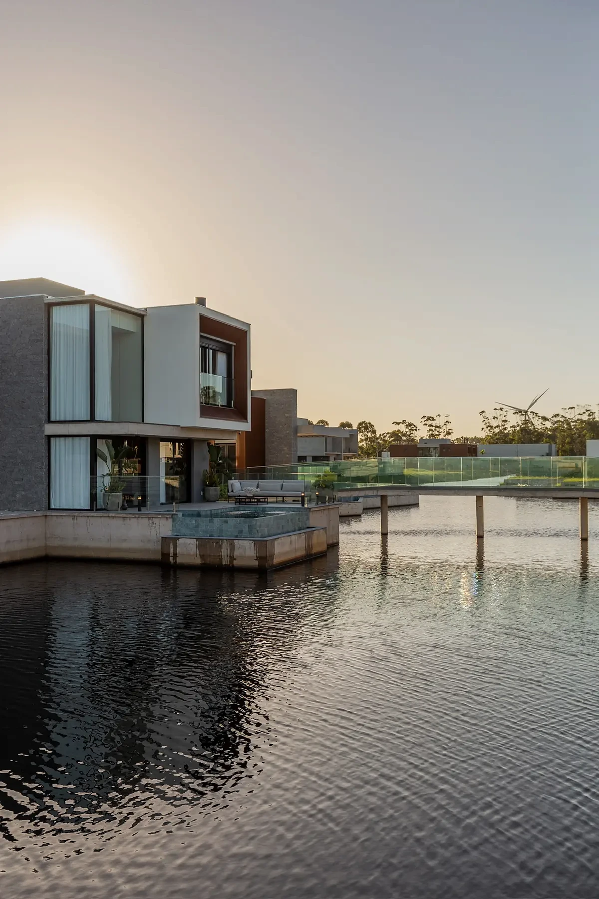 Casa Pequi implantada junto ao lago ao entardecer.