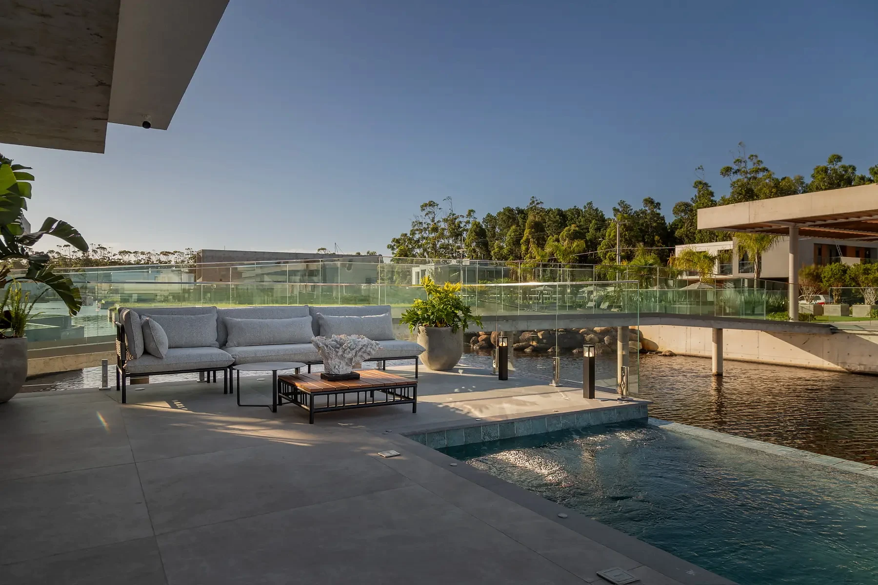 Área externa da Casa Pequi com piscina, espreguiçadeiras e vista para o lago.